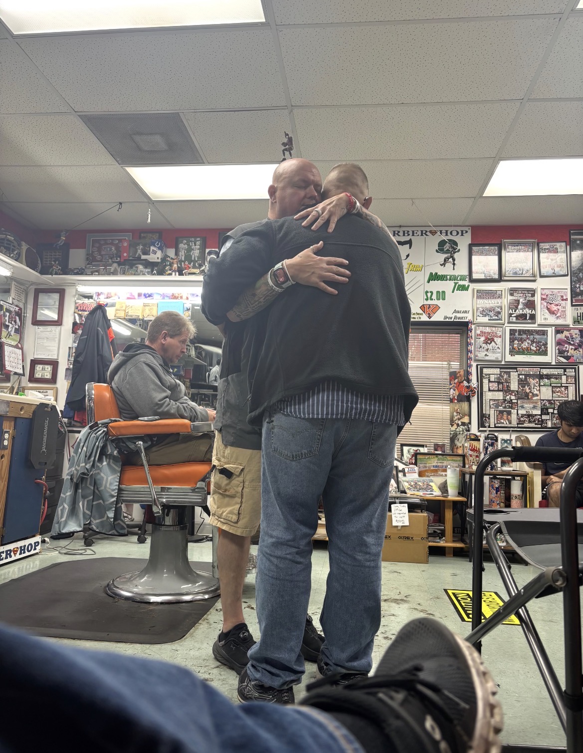 Barber greeting a longtime customer with a hug in the shop